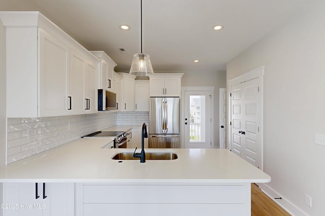 128 Sea Oaks Ct, North Topsail Beach, NC 28460 - kitchen featuring appliances with stainless steel finishes, a sink, tasteful backsplash, light countertops, and recessed lighting