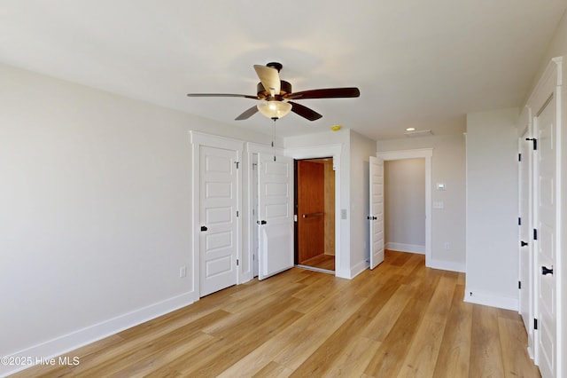 128 Sea Oaks Ct, North Topsail Beach, NC 28460 - unfurnished bedroom with baseboards, light wood-style flooring, recessed lighting, ceiling fan, and multiple closets