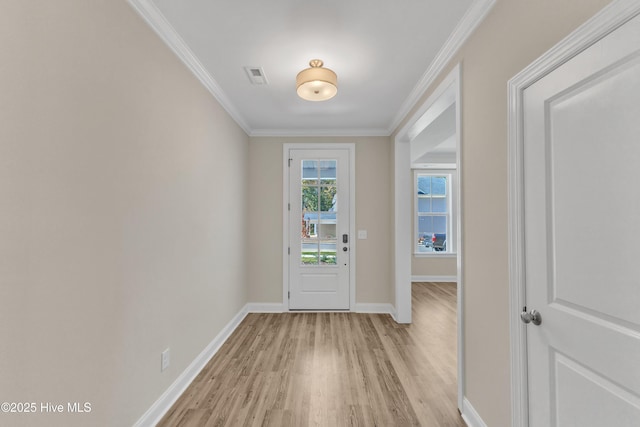 foyer featuring light wood-style floors, ornamental molding, and baseboards
