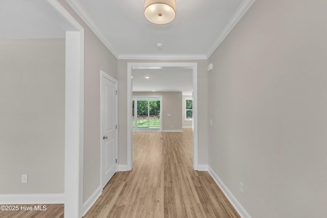 hallway featuring light wood-type flooring, baseboards, and crown molding