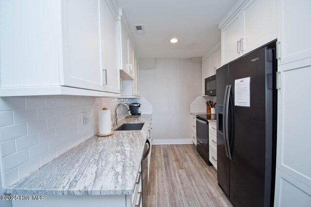 565 Salter Path Rd Unit S-5, Pine Knoll Shores, NC 28512 - kitchen with a sink, black appliances, white cabinetry, light wood finished floors, and backsplash