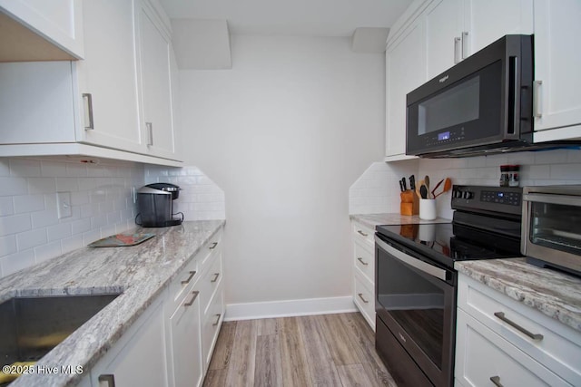 565 Salter Path Rd Unit S-5, Pine Knoll Shores, NC 28512 - kitchen with black microwave, stainless steel electric stove, tasteful backsplash, light wood finished floors, and white cabinetry