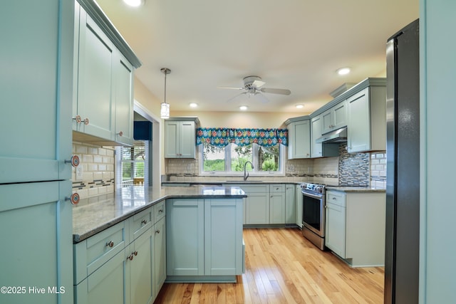 265 Creek View Dr, Sunset Beach, NC 28468 - kitchen with a sink, stainless steel electric stove, ceiling fan, under cabinet range hood, and light wood finished floors