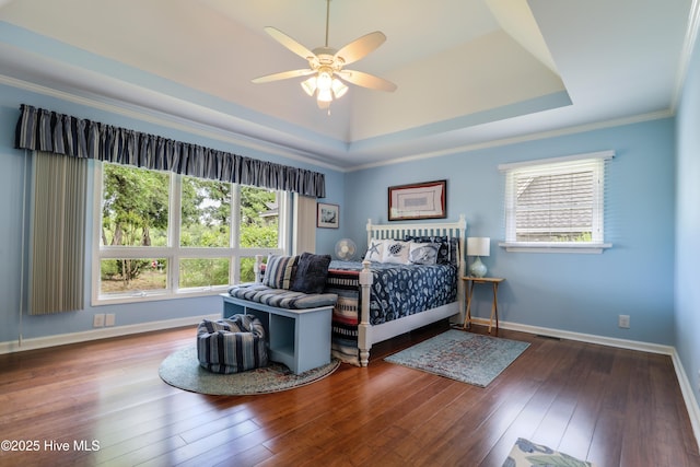 265 Creek View Dr, Sunset Beach, NC 28468 - bedroom featuring hardwood / wood-style flooring, a tray ceiling, baseboards, crown molding, and ceiling fan
