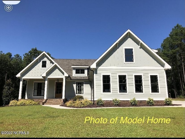 779 Breezewood Dr SE, Bolivia, NC 28422 - view of front of home featuring board and batten siding, a front yard, and a porch
