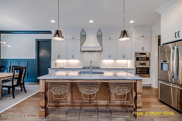 779 Breezewood Dr SE, Bolivia, NC 28422 - kitchen featuring stainless steel appliances, custom range hood, dark wood-style flooring, white cabinetry, and a breakfast bar area