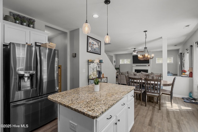 140 Timberwood Dr, Cameron, NC 28326 - kitchen with stainless steel refrigerator with ice dispenser, wood finished floors, a fireplace, a kitchen island, and light stone counters