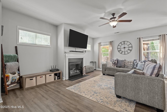140 Timberwood Dr, Cameron, NC 28326 - living room with a fireplace with raised hearth, plenty of natural light, wood finished floors, and a ceiling fan