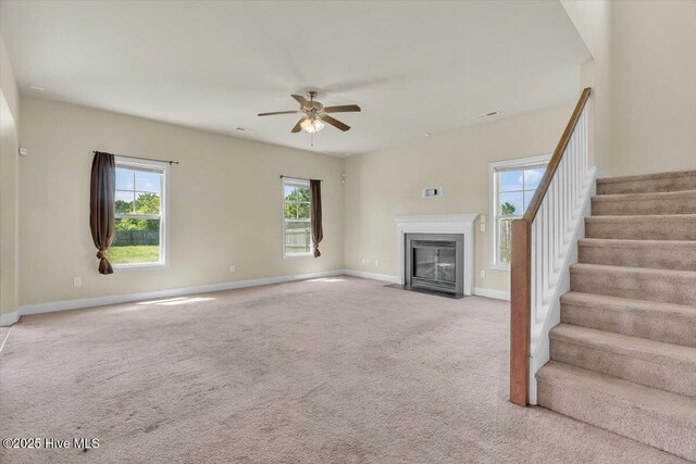 132 Turquoise Dr, Jacksonville, NC 28546 - unfurnished living room featuring ceiling fan, plenty of natural light, a fireplace with flush hearth, and stairway