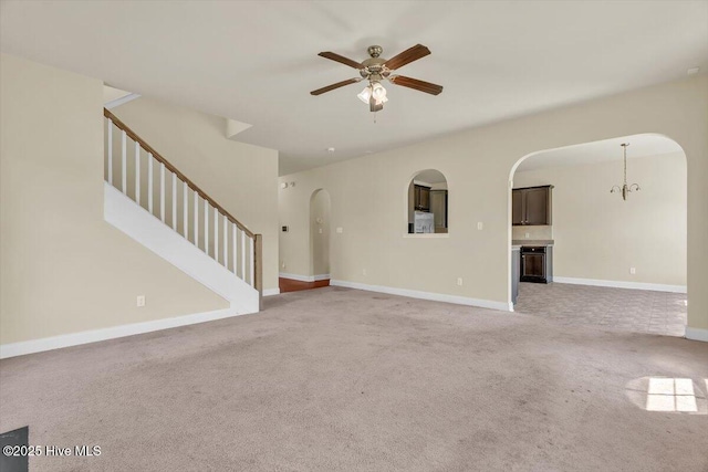 132 Turquoise Dr, Jacksonville, NC 28546 - unfurnished living room featuring arched walkways, a ceiling fan, stairs, and light carpet