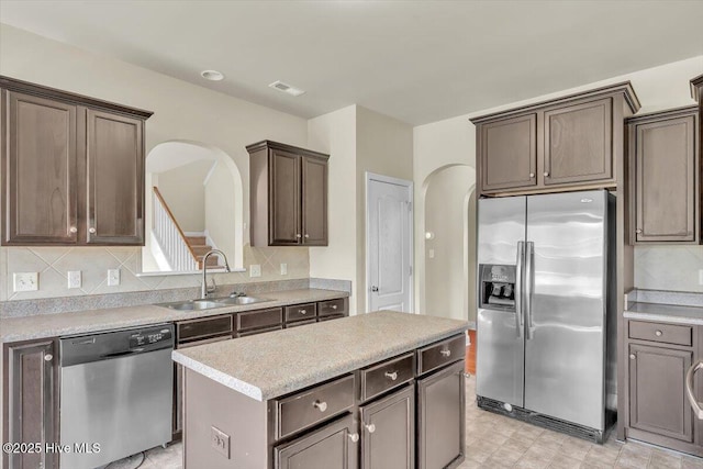 132 Turquoise Dr, Jacksonville, NC 28546 - kitchen with stainless steel appliances, a sink, arched walkways, and a center island
