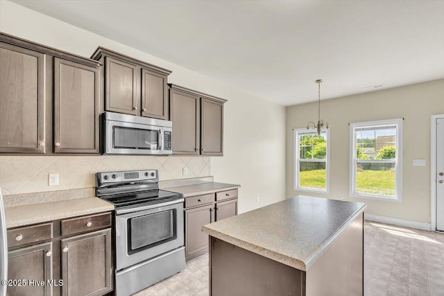 132 Turquoise Dr, Jacksonville, NC 28546 - kitchen with stainless steel appliances, a center island, decorative backsplash, light flooring, and pendant lighting