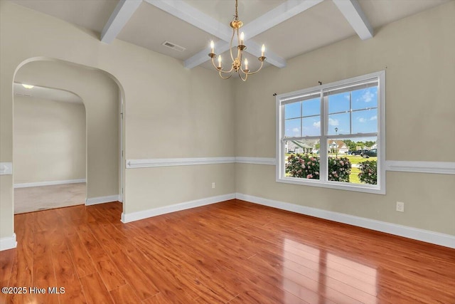 132 Turquoise Dr, Jacksonville, NC 28546 - unfurnished room featuring wood finished floors, a chandelier, beamed ceiling, baseboards, and arched walkways