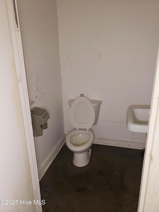 809 Conway Rd, Fair Bluff, NC 28439 - bathroom with concrete flooring, toilet, a sink, and baseboards