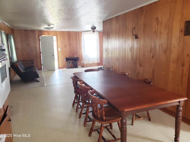 809 Conway Rd, Fair Bluff, NC 28439 - dining space with wood walls, a wood stove, and finished concrete floors