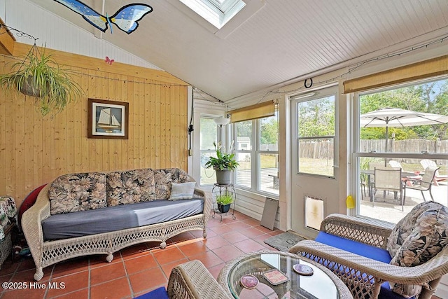 sunroom with lofted ceiling, a skylight, and healthy amount of natural light