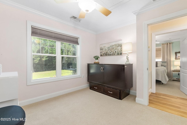 sitting room with ornamental molding, a ceiling fan, baseboards, and light colored carpet