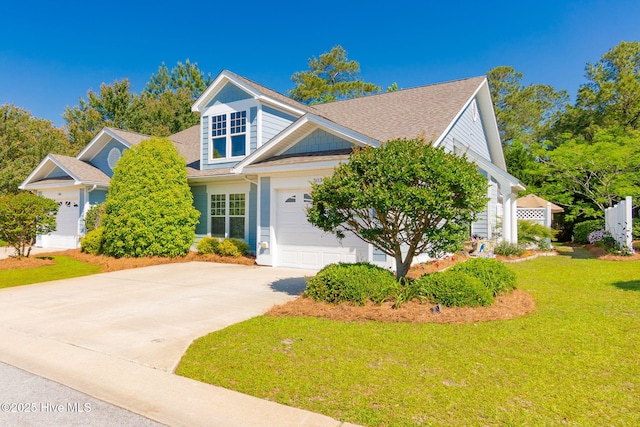 view of front of house featuring concrete driveway, a front lawn, a garage, and a shingled roof
