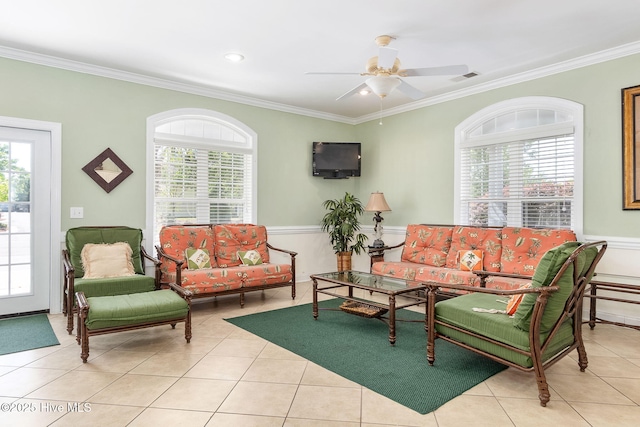 living room featuring ornamental molding, ceiling fan, tile patterned flooring, and a wainscoted wall