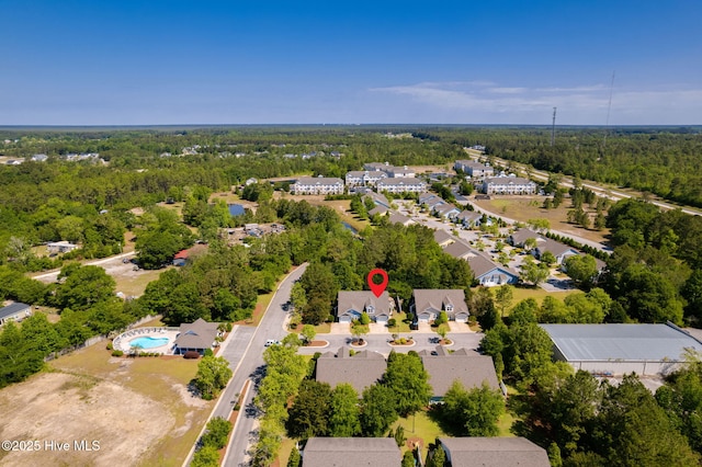 bird's eye view of a heavily wooded area and a pool area