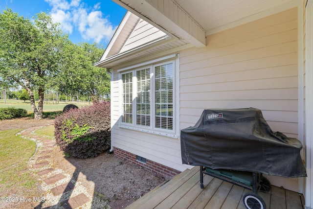 wooden deck featuring a grill