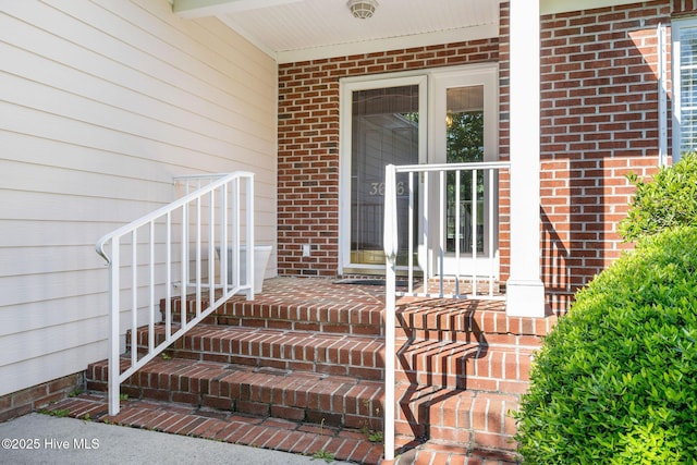 entrance to property featuring brick siding