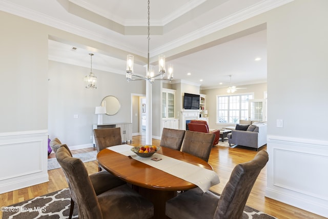 2016 Ashbrook Ct, Leland, NC 28451 - dining area with light wood finished floors, crown molding, a wainscoted wall, a chandelier, and a fireplace