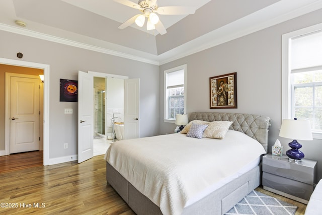 2016 Ashbrook Ct, Leland, NC 28451 - bedroom featuring wood finished floors, crown molding, baseboards, a raised ceiling, and ensuite bath