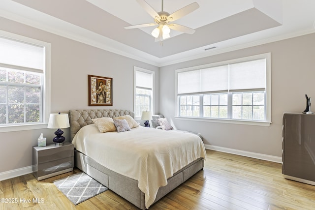 2016 Ashbrook Ct, Leland, NC 28451 - bedroom with a tray ceiling, multiple windows, wood finished floors, baseboards, and ornamental molding