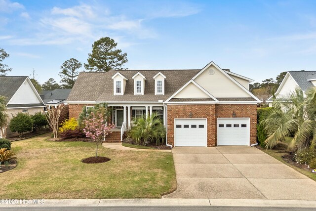 2016 Ashbrook Ct, Leland, NC 28451 - view of front of home featuring brick siding, concrete driveway, a front yard, and covered porch