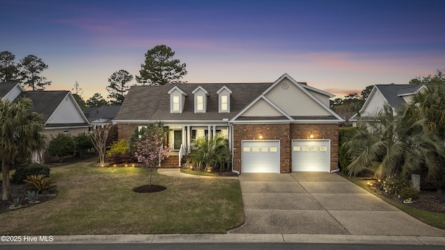 2016 Ashbrook Ct, Leland, NC 28451 - view of front facade with brick siding, a yard, concrete driveway, and a porch