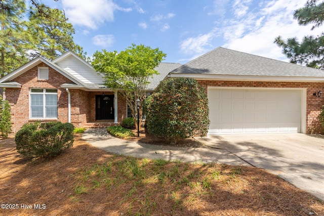 view of front facade featuring concrete driveway, brick siding, a garage, and a shingled roof