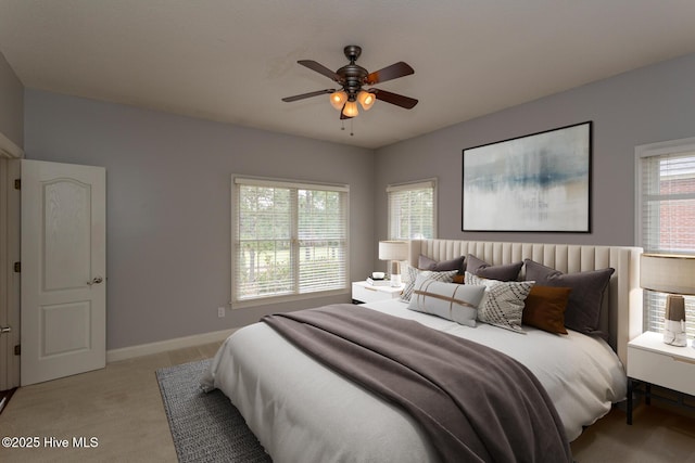 bedroom featuring light colored carpet, ceiling fan, and baseboards