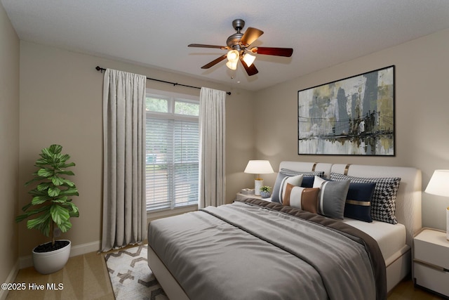 bedroom with baseboards, carpet flooring, and a ceiling fan