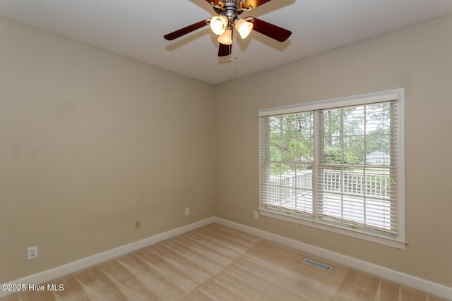 empty room with baseboards, light colored carpet, and a ceiling fan