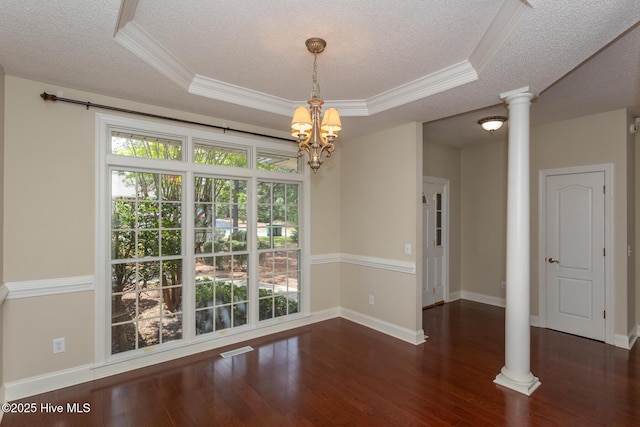 unfurnished dining area with decorative columns, a textured ceiling, ornamental molding, wood finished floors, and a chandelier