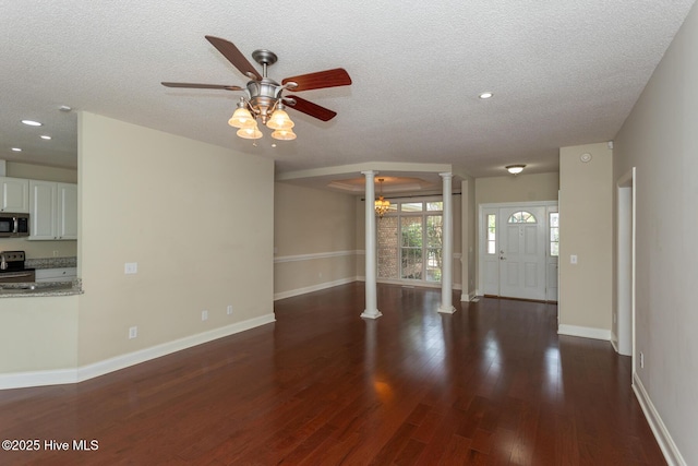 unfurnished living room with decorative columns, ceiling fan, a textured ceiling, wood finished floors, and baseboards