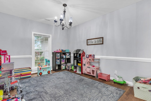 707 Brown Pelican Ln, Hampstead, NC 28443 - recreation room with a chandelier, wood finished floors, and baseboards