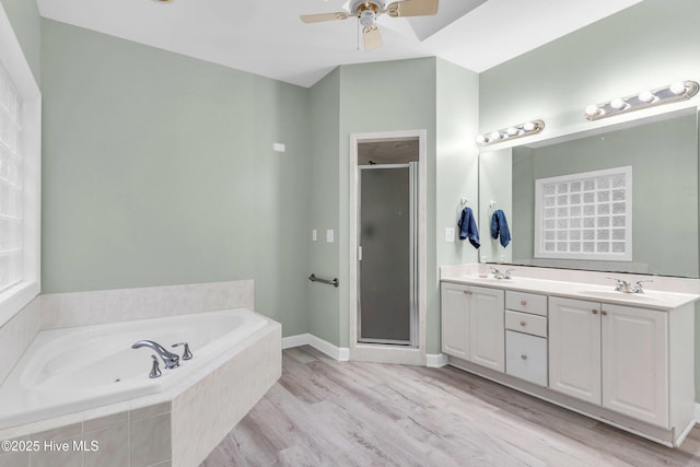 707 Brown Pelican Ln, Hampstead, NC 28443 - full bathroom with a stall shower, a bath, a ceiling fan, wood finished floors, and double vanity