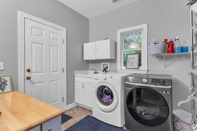 707 Brown Pelican Ln, Hampstead, NC 28443 - clothes washing area with cabinet space, washing machine and dryer, and light tile patterned floors