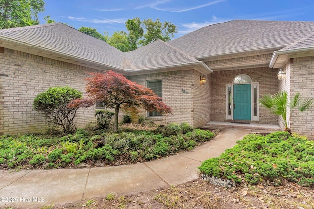 707 Brown Pelican Ln, Hampstead, NC 28443 - doorway to property with a shingled roof and brick siding