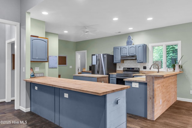 707 Brown Pelican Ln, Hampstead, NC 28443 - kitchen with butcher block countertops, appliances with stainless steel finishes, a peninsula, and recessed lighting
