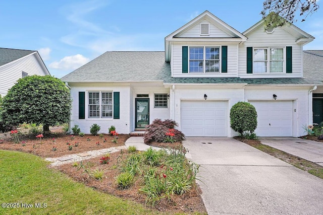view of front of home featuring driveway, an attached garage, and a shingled roof