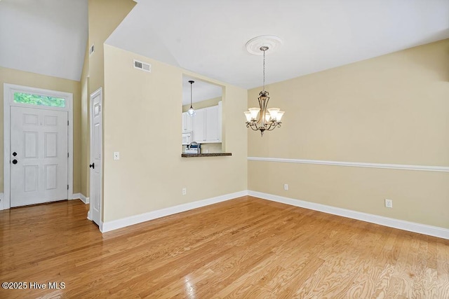 unfurnished dining area with light wood-style flooring, baseboards, and a chandelier