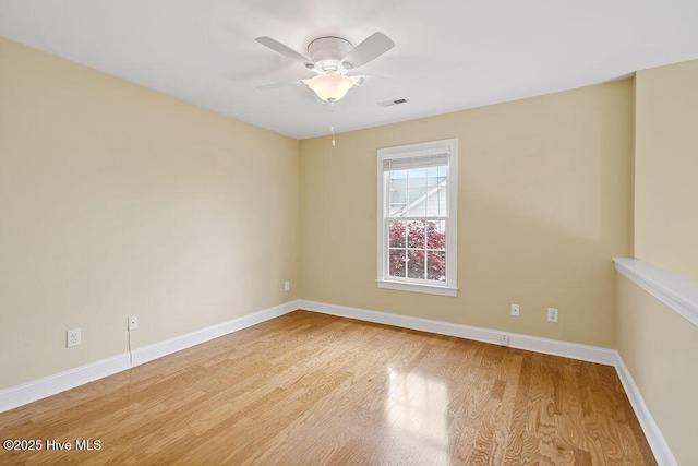 spare room with wood finished floors, baseboards, and ceiling fan