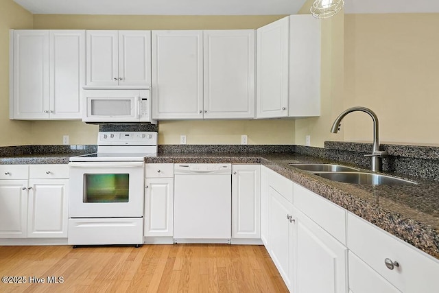 kitchen featuring white appliances, a sink, white cabinets, and light wood-type flooring