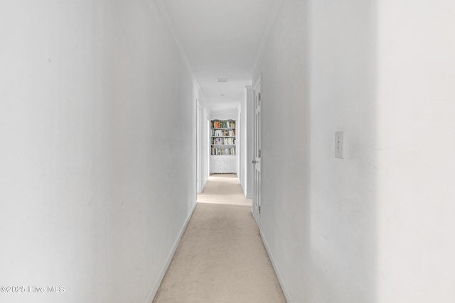 hall with baseboards and light colored carpet