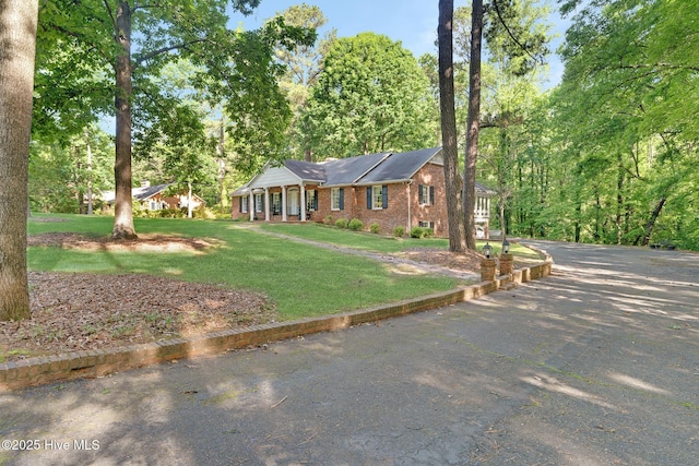 ranch-style home featuring brick siding and a front yard
