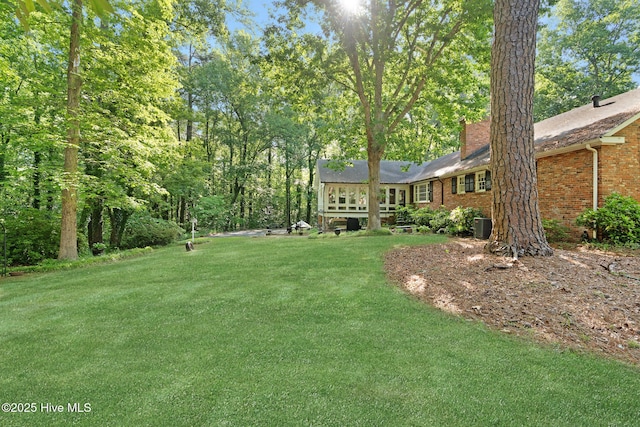 view of green lawn featuring central AC