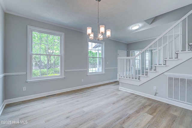 unfurnished dining area featuring stairs, crown molding, a chandelier, wood finished floors, and a textured ceiling